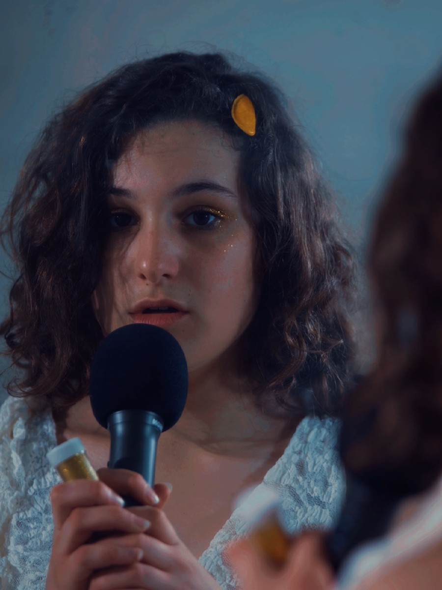 Performer with a microphone, still from Poetry Slam